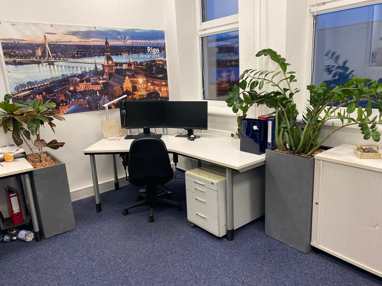 An der Wand über dem Schreibtisch hängt ein Bild einer Stadt.