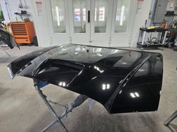 Freshly painted vehicle hood prepared for reinstallation at Elmwood Collision in Kenmore, NY.