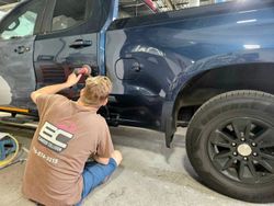 Technician performing final polishing and finishing work on a repaired pickup truck at Elmwood Collision in Kenmore, NY.