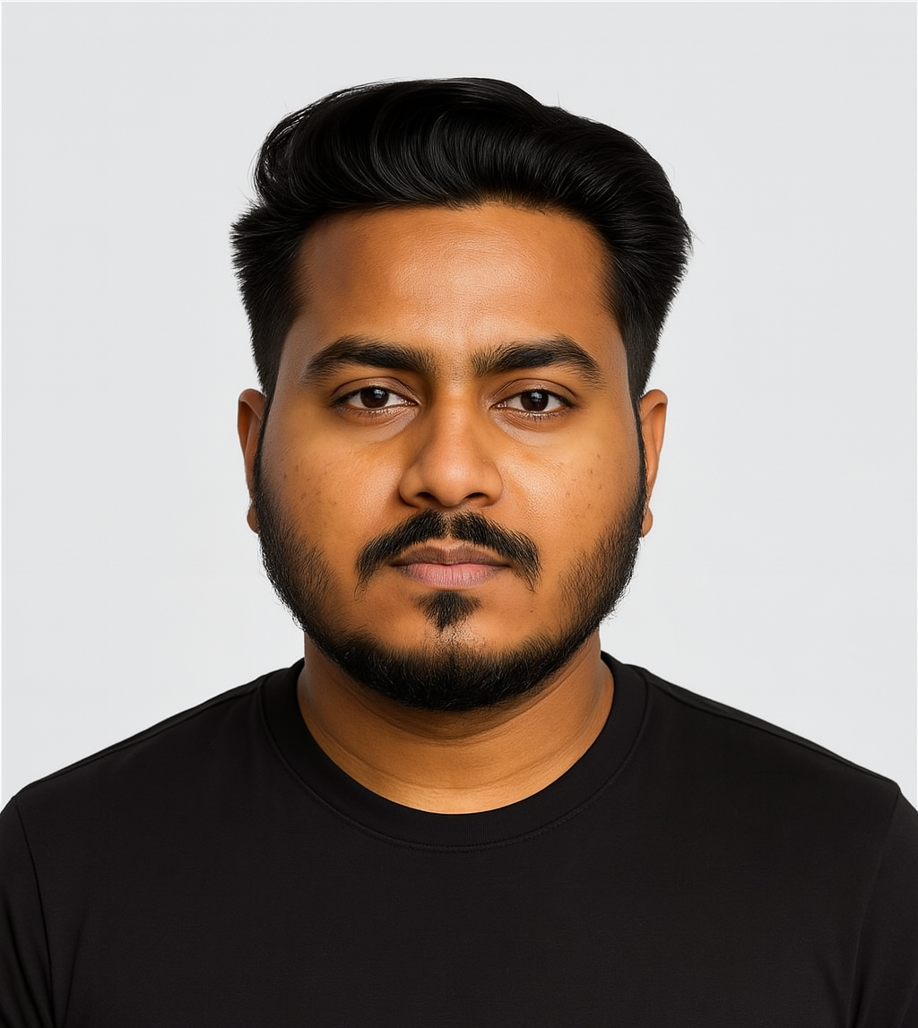 Una persona con cabello corto y oscuro, barba y una camiseta negra sobre un fondo claro liso.
