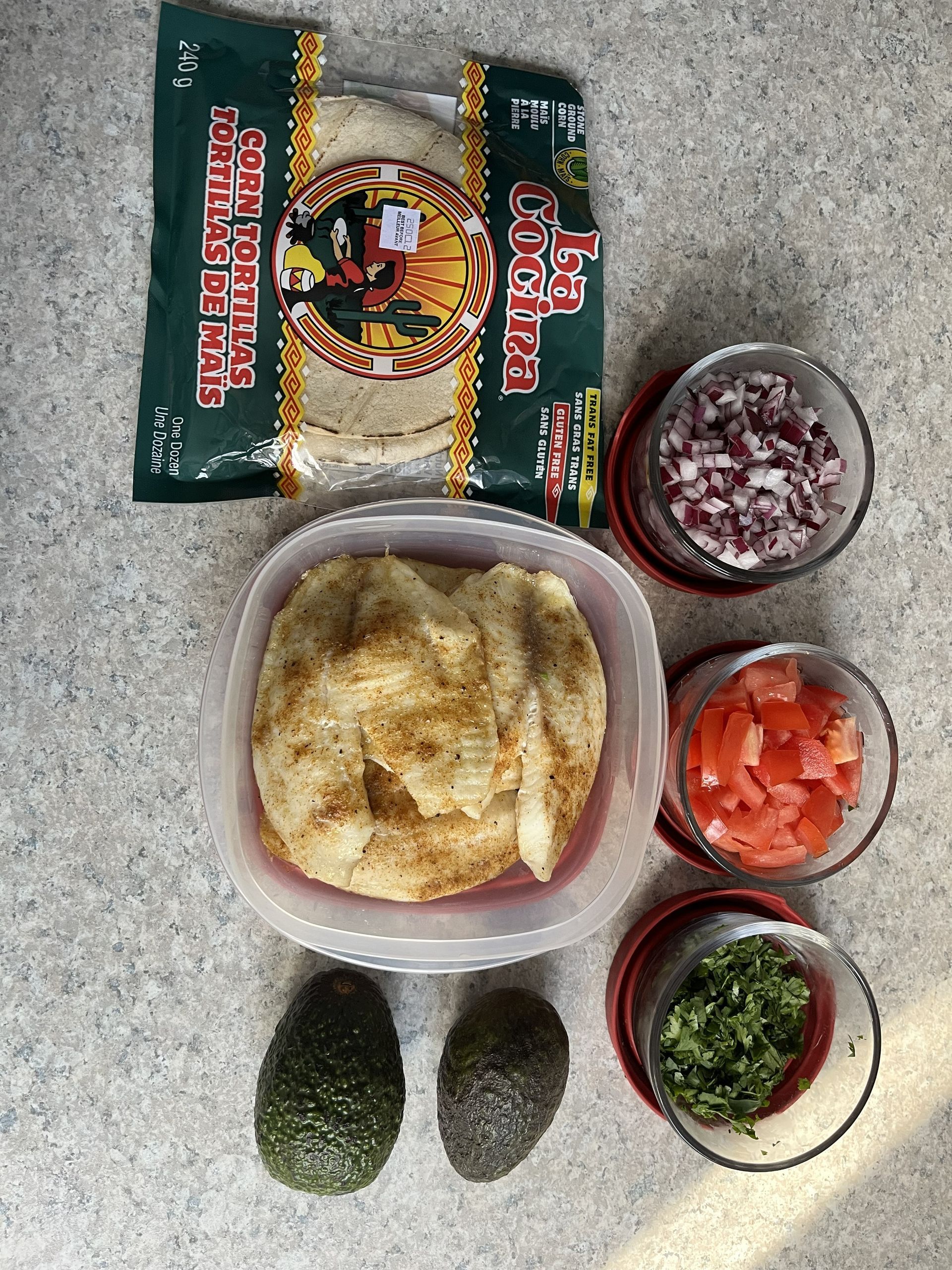 Ingredients for guacamole: avocados, chopped onion, tomatoes, cilantro, and a seasoning packet.