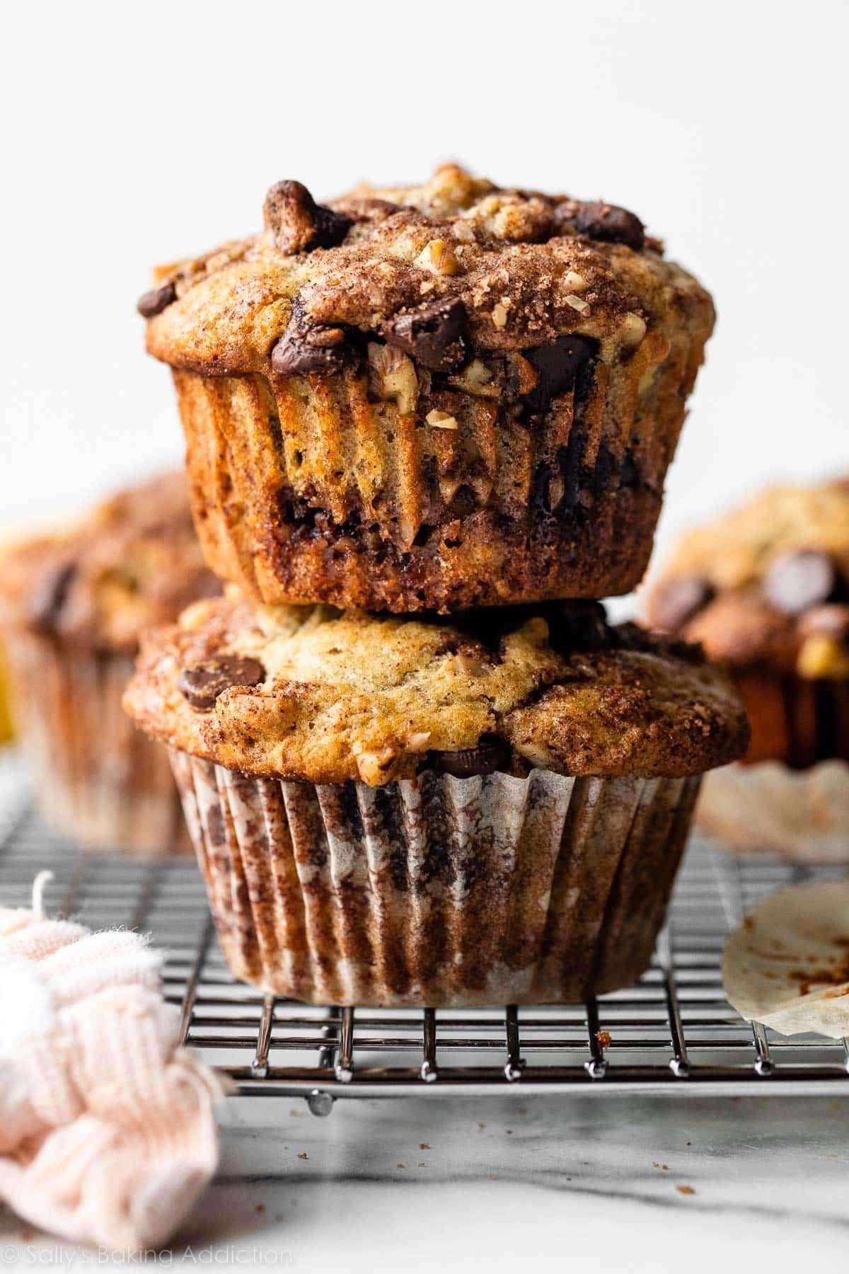 Stacked banana muffins on a wire rack, topped with crumbly streusel and chocolate chips