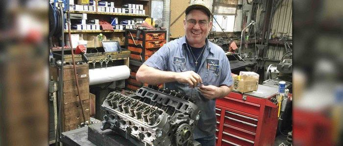 Mechanic smiling while fixing an engine