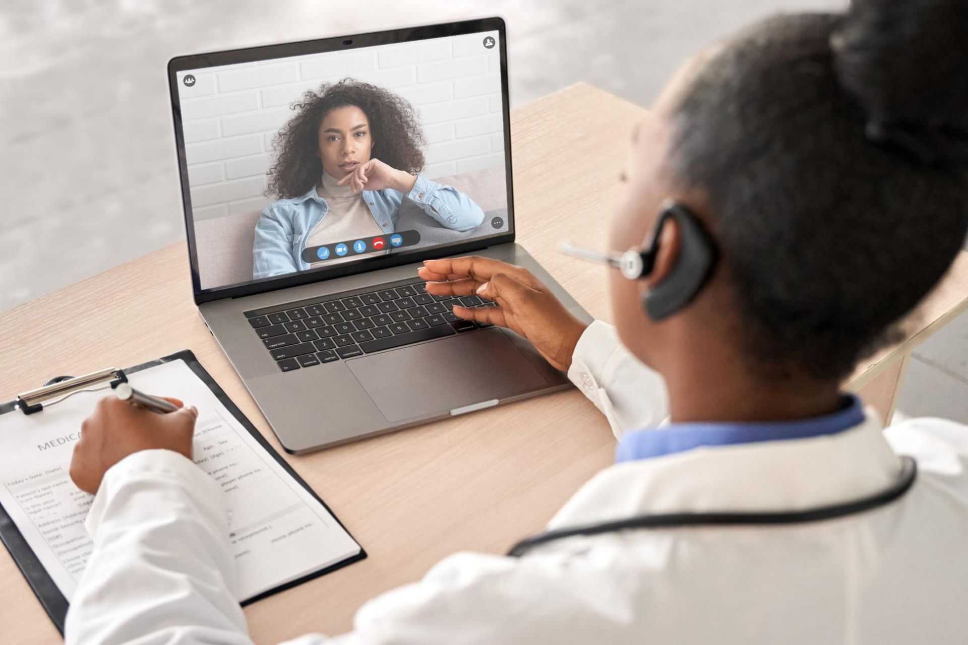 A Doctor in a White Coat Conducts a Telehealth Consultation — EastCoast Women's Centre In Maryborough, QLD