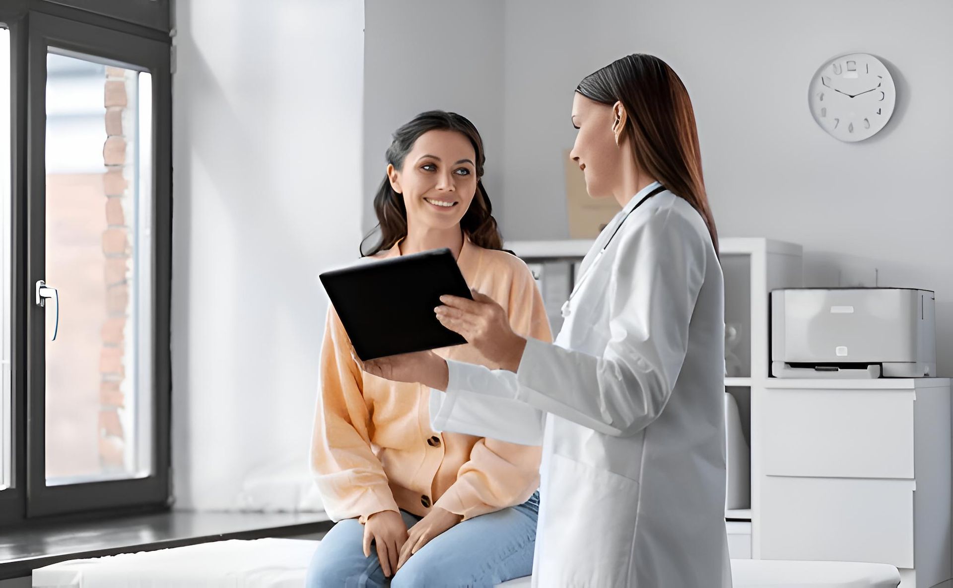 A Doctor is Talking to a Patient While Holding a Tablet — Eastcoast Women's Centre in Nambour, QLD