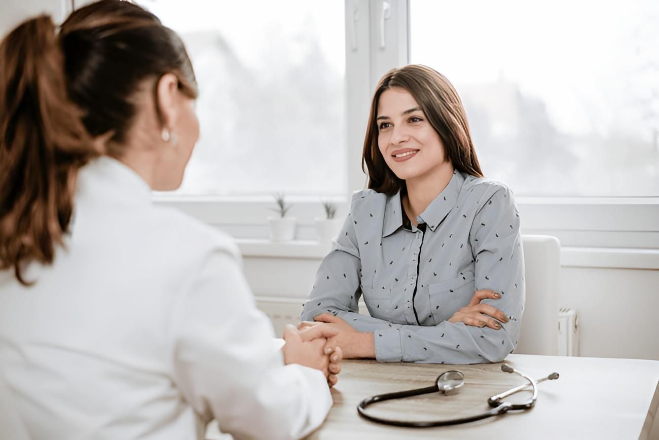 A Woman is Sitting at a Table Talking to a Doctor — Eastcoast Women's Centre in Nambour, QLD
