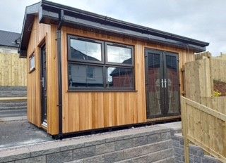 a small wooden building with a fence in front of it .