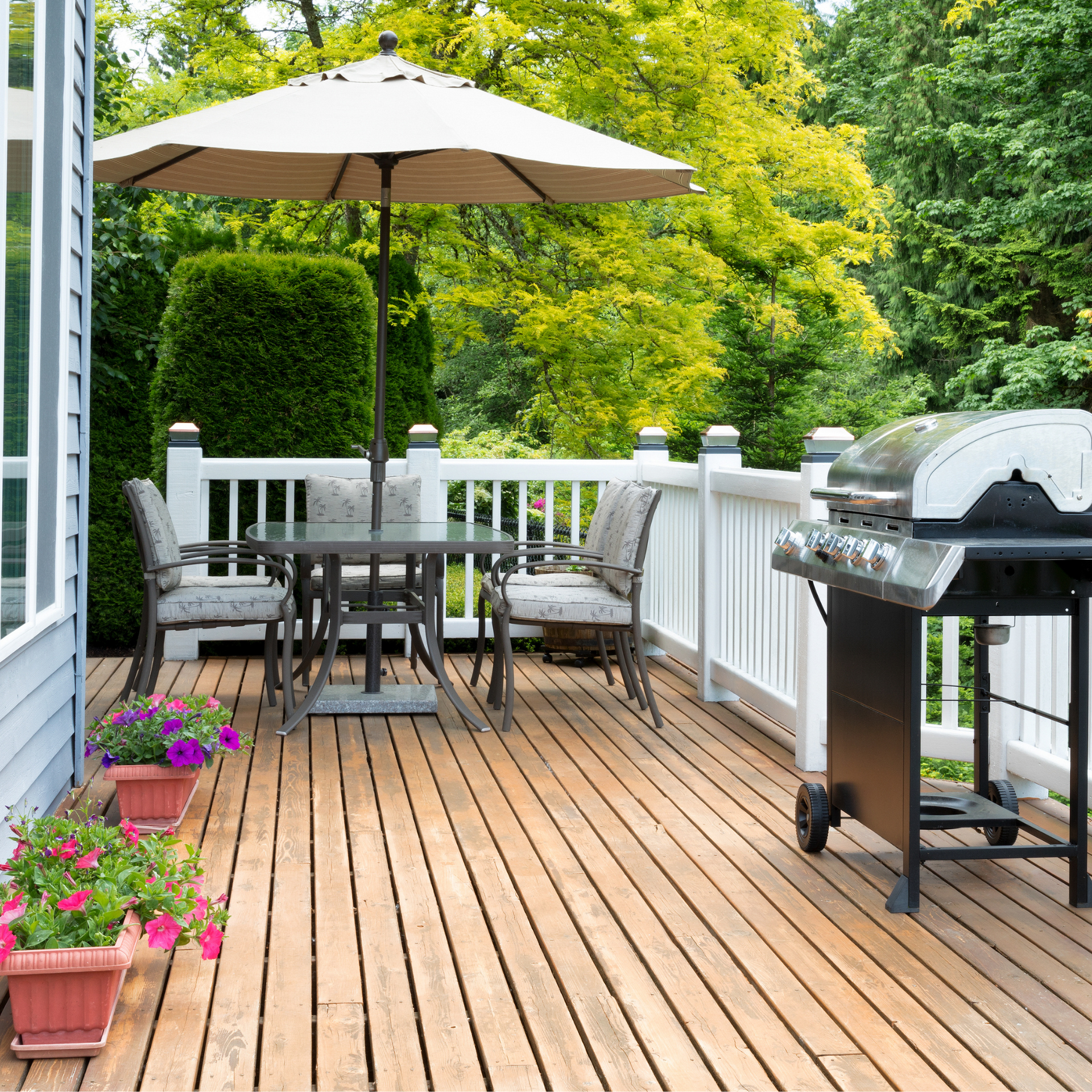 A wooden deck with a table and chairs and an umbrella