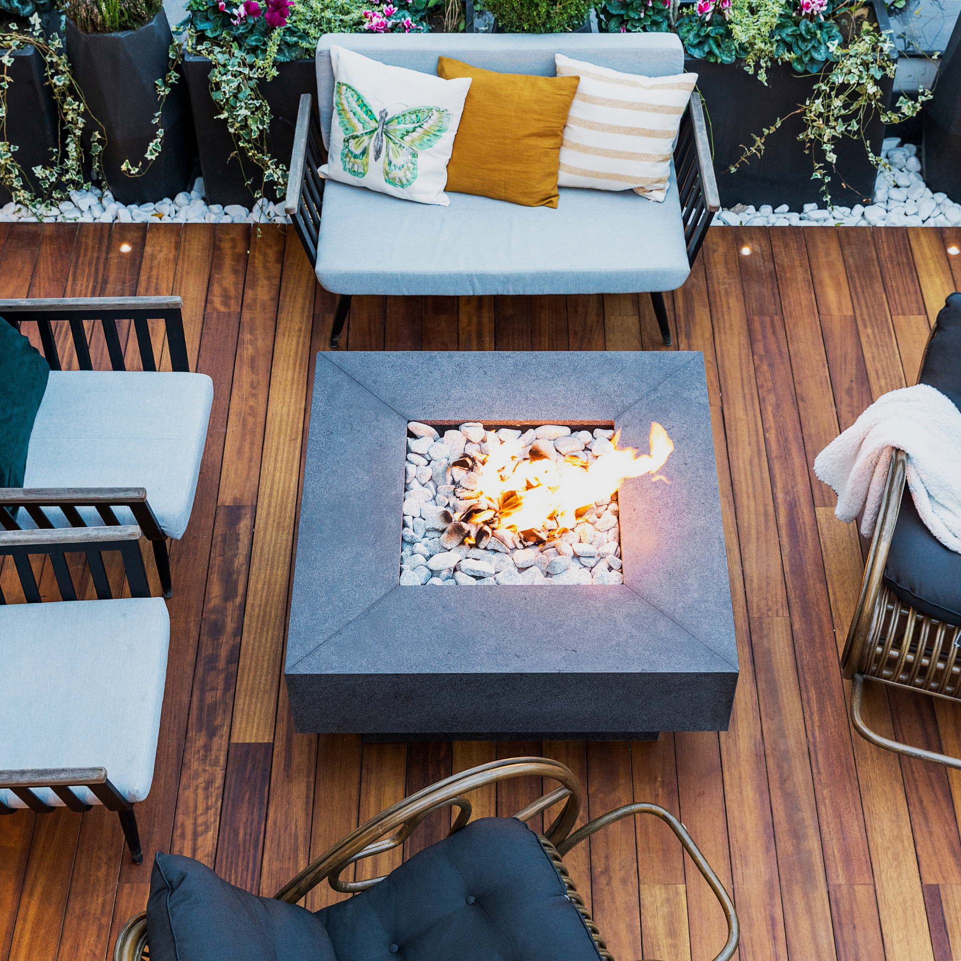 A fire pit surrounded by dark stain wood