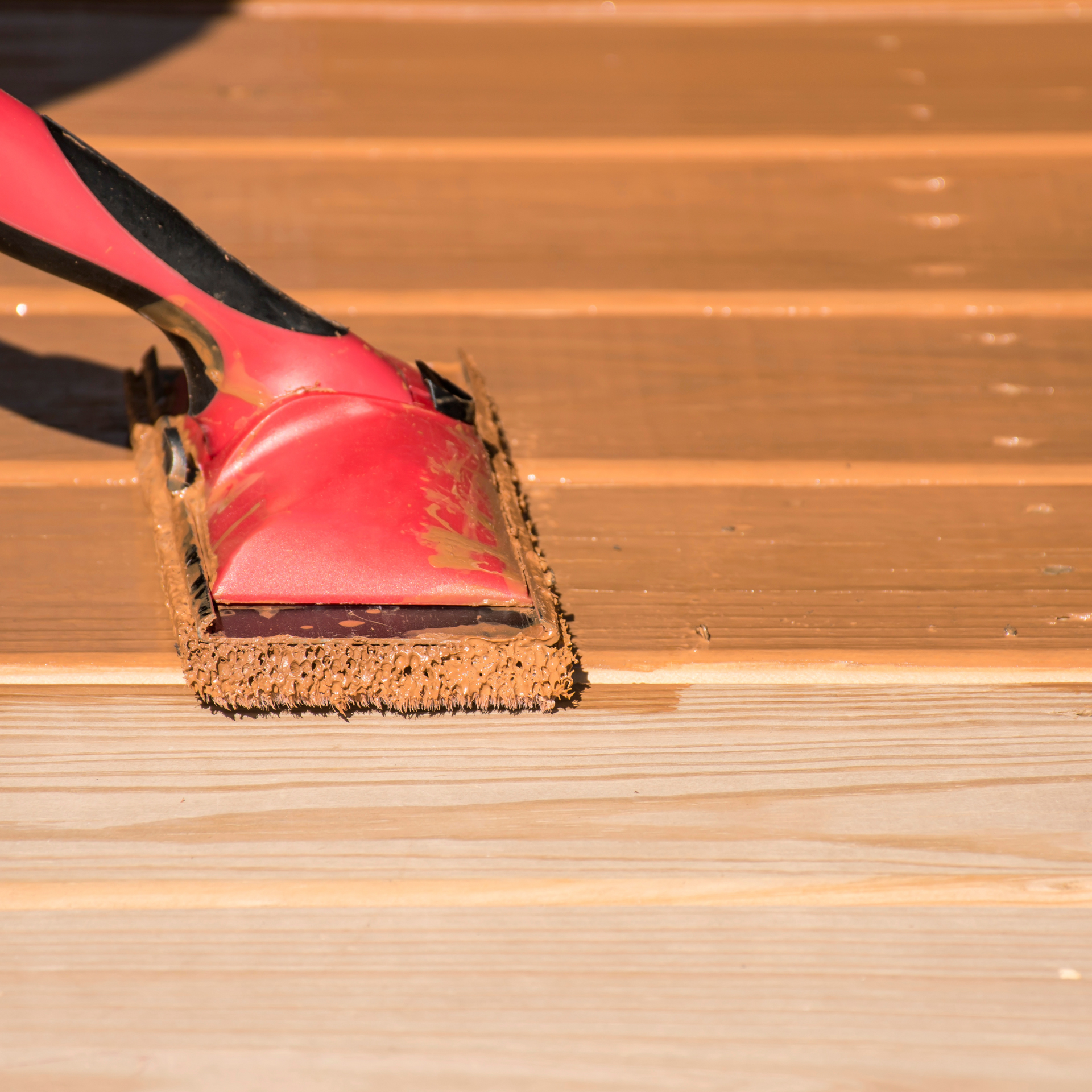 A person is sanding a wooden surface with a sander.