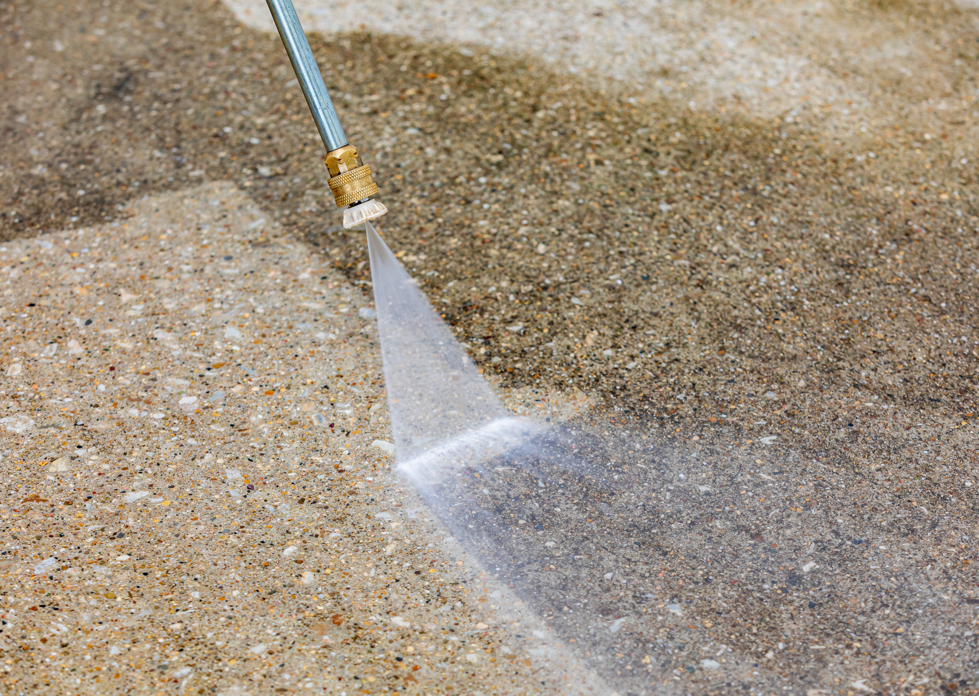 A person is using a high pressure washer to clean a concrete floor.