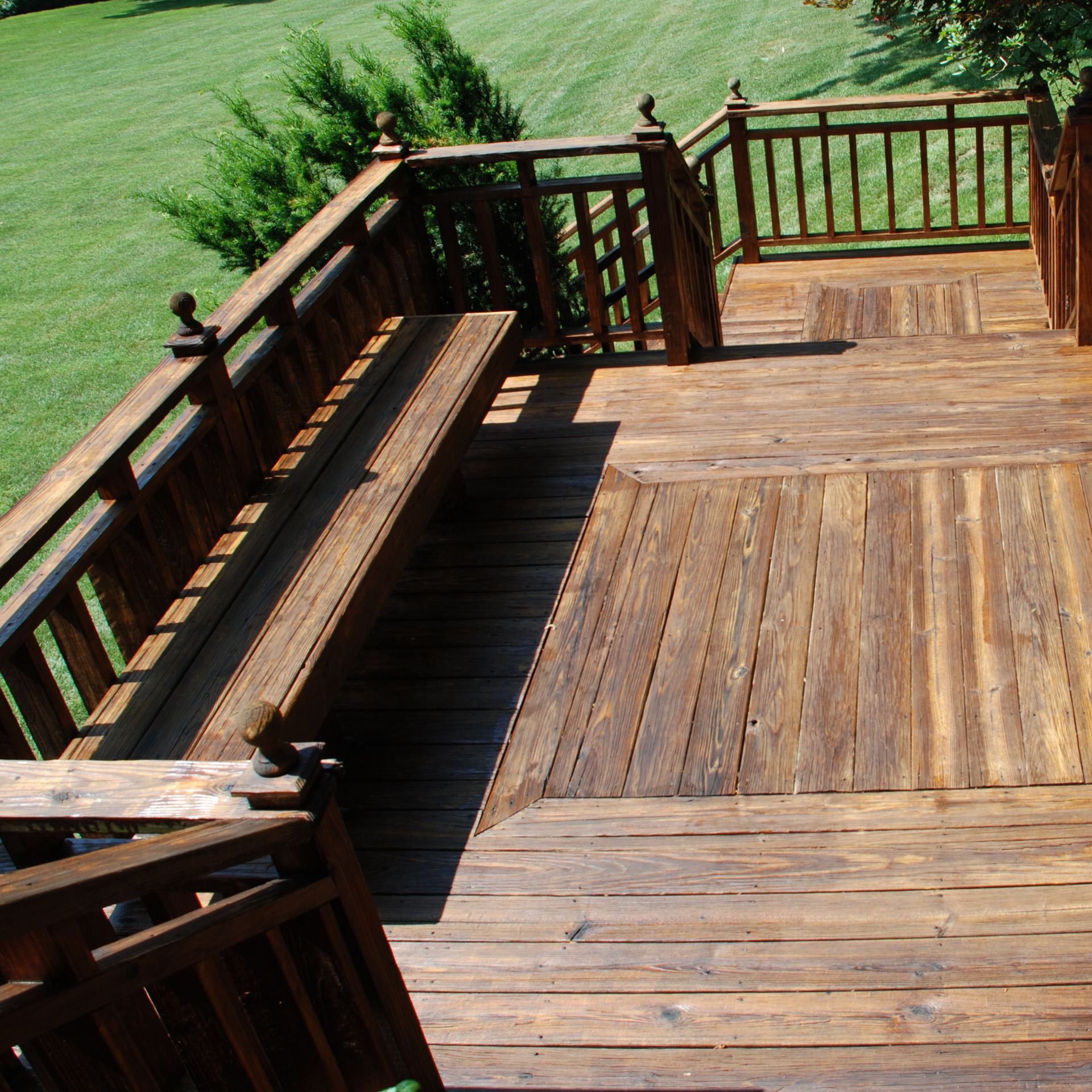 A wooden deck with a bench and stairs leading up to it