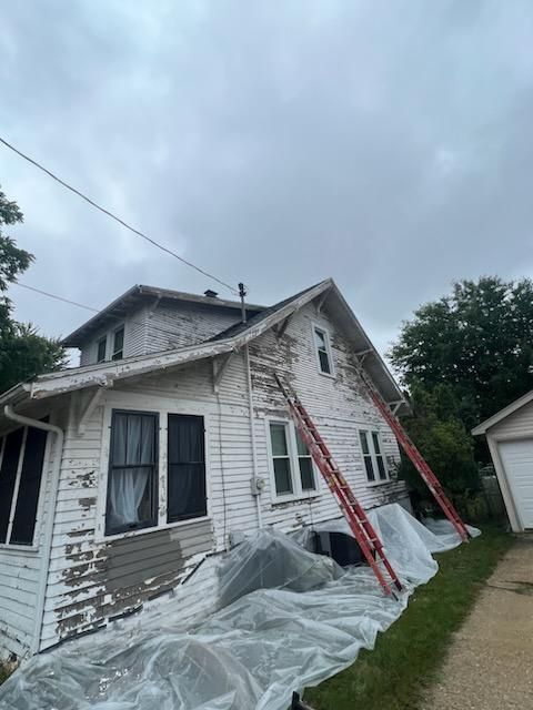 A white house with a ladder leaning against it