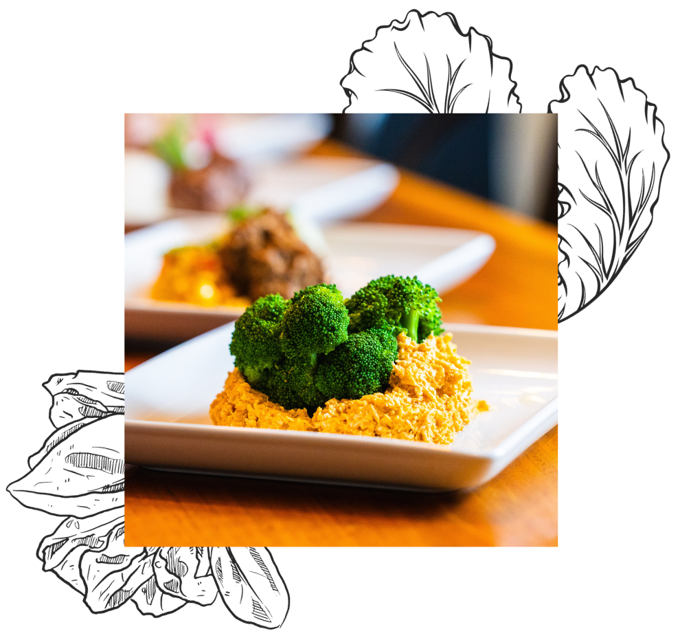 Close up of a plate of buffalo chicken with broccoli on top