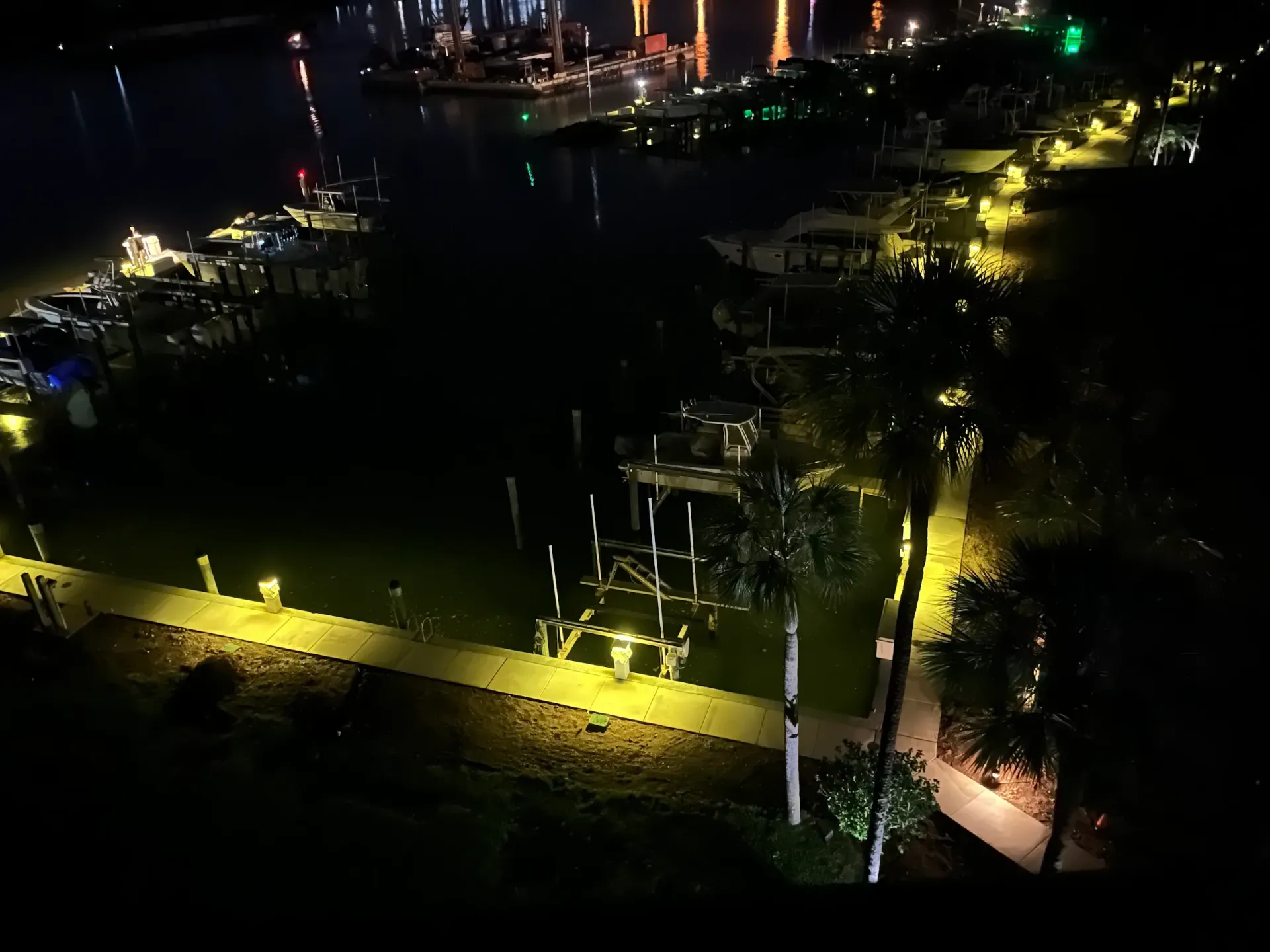 An aerial view of a marina at night with boats docked.