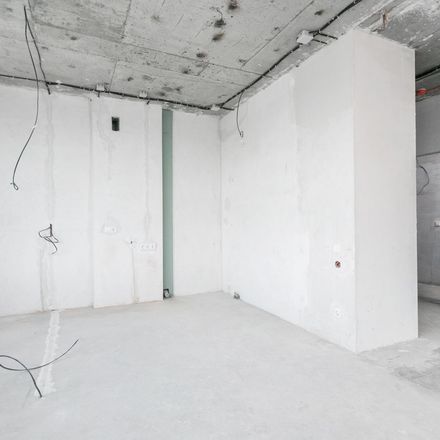 An empty room with white walls and a concrete floor.