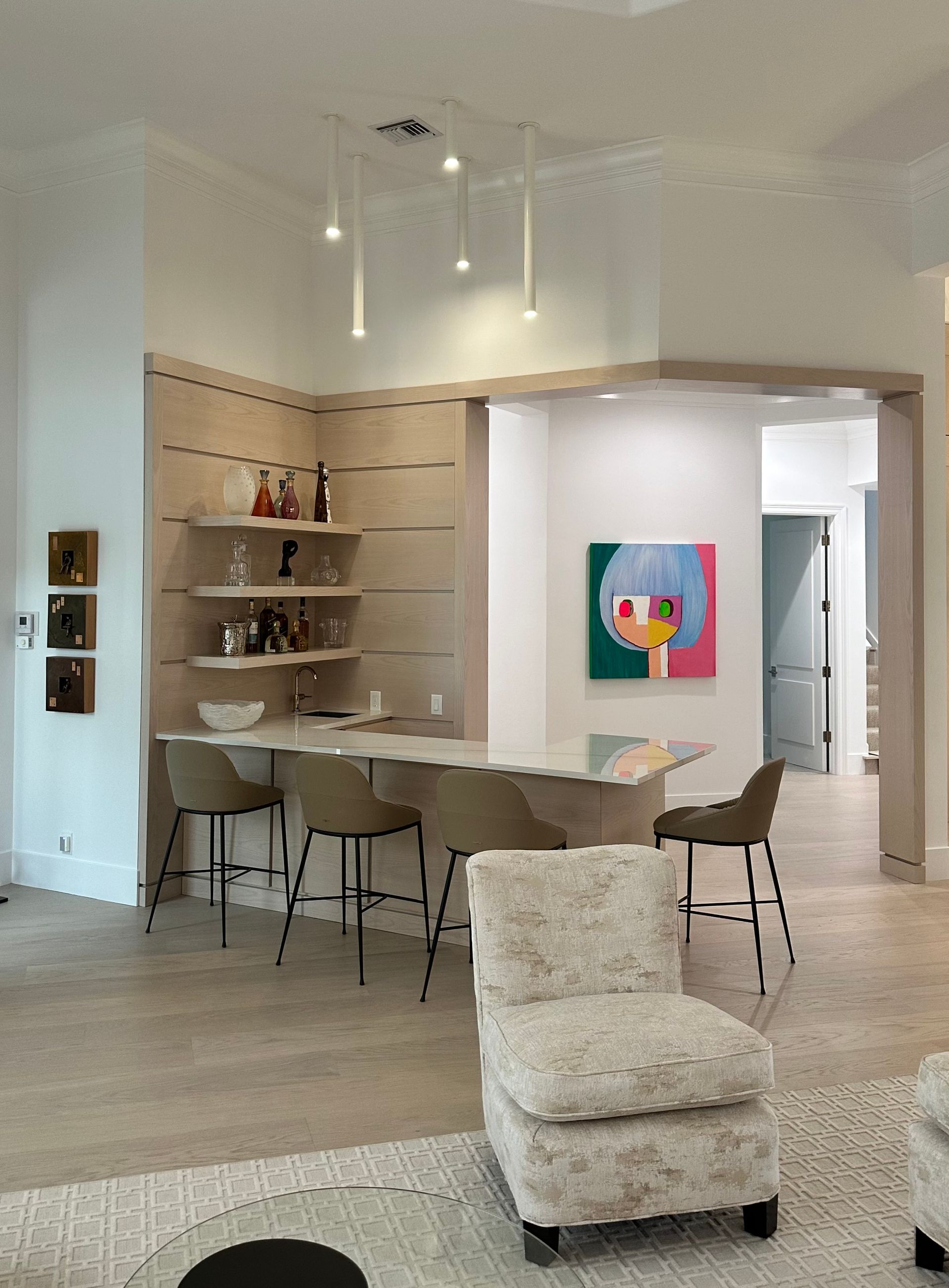 A living room with a table and chairs and a painting on the wall