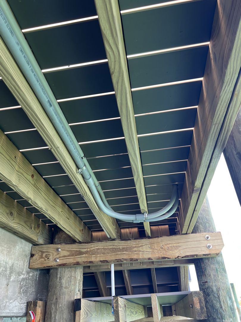 The underside of a wooden deck with a pipe going through it
