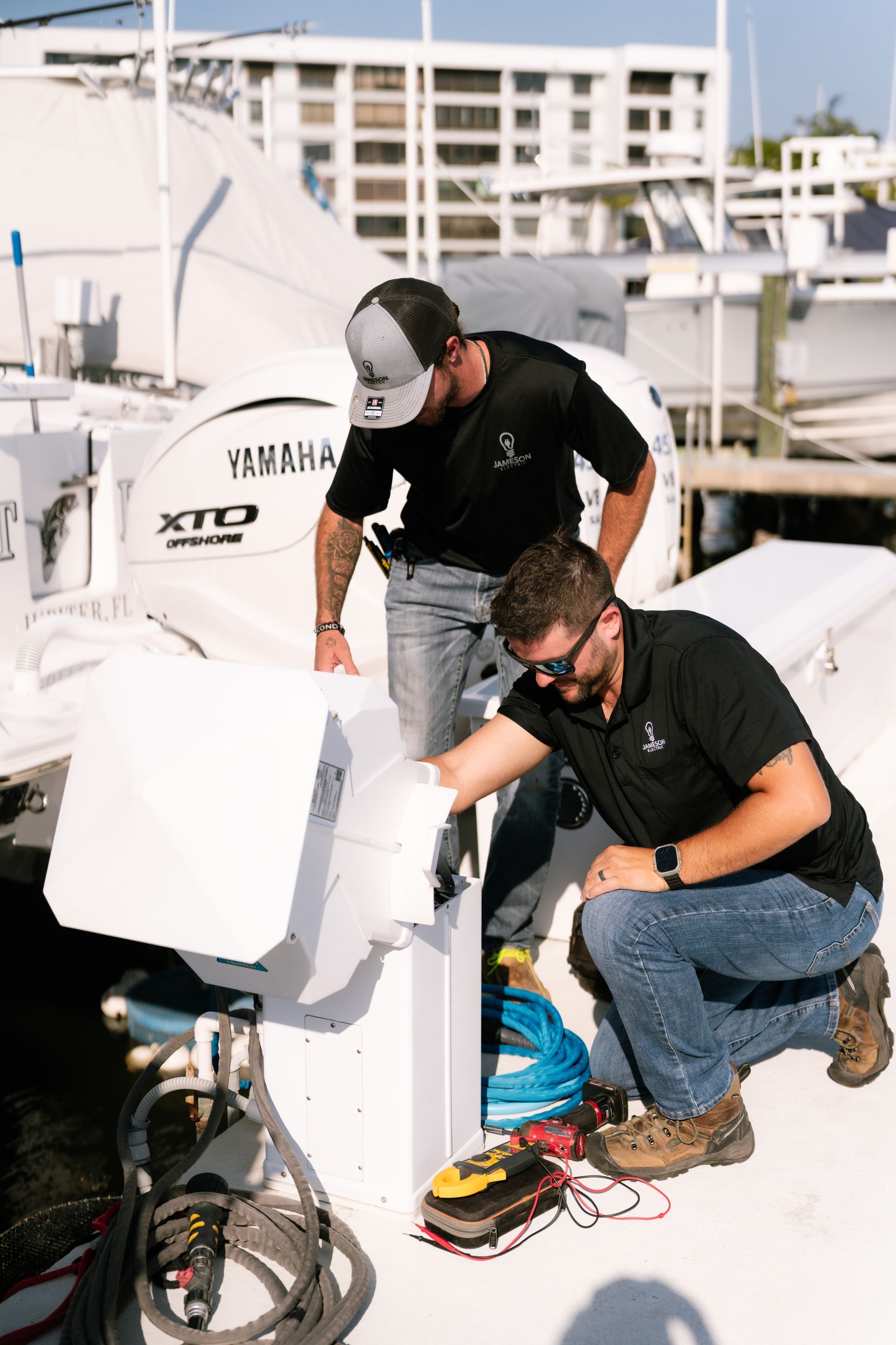 Two men are working on a boat in a marina.