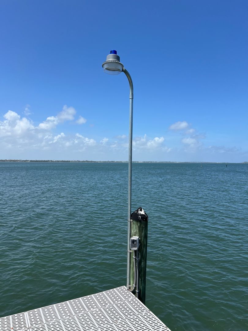 A dock with a light on it overlooking a body of water.