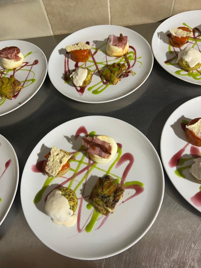 Porzioni di dessert gourmet impiattate con salse colorate su un vassoio da ristorante