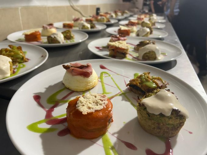 Antipasti gourmet disposti su un lungo tavolo, accompagnati da salse e guarnizioni colorate.
