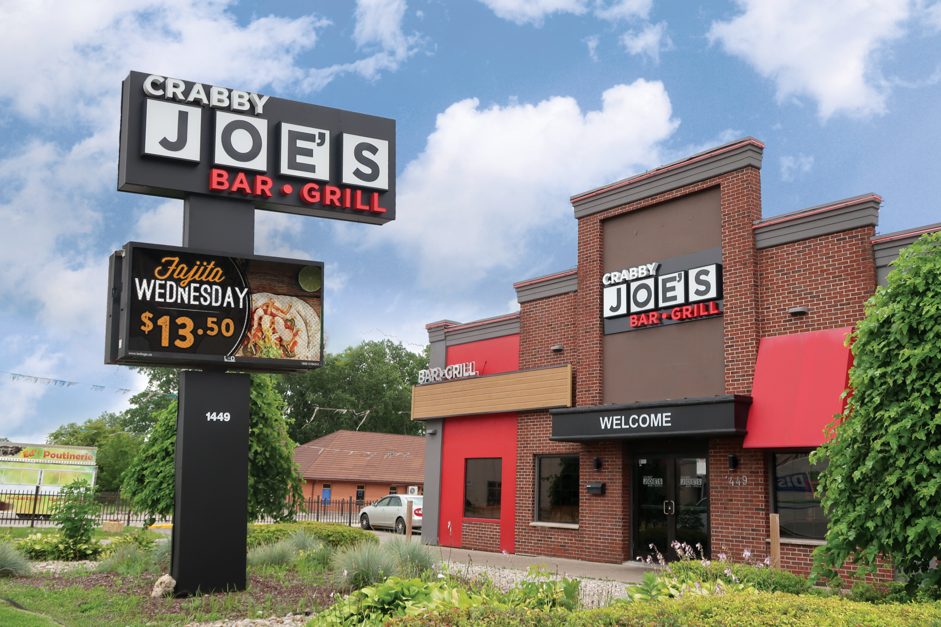 Crabby Joe's Bar & Grill brick storefront with red awnings and roadside sign under a cloudy sky