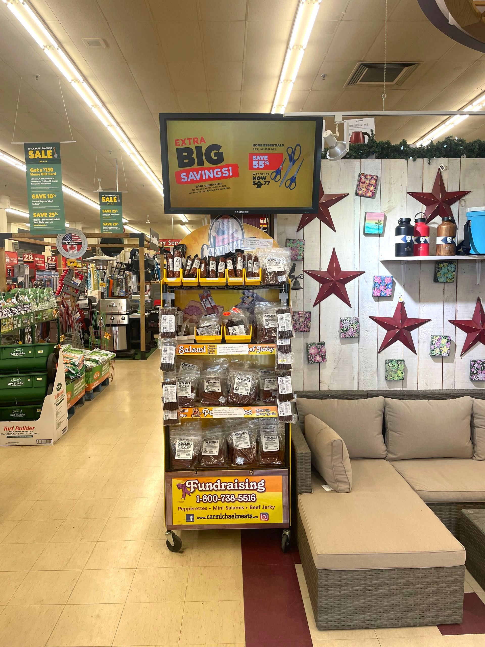 Store display with a beige sectional sofa, red star wall decor, and a Big Savings sale sign.