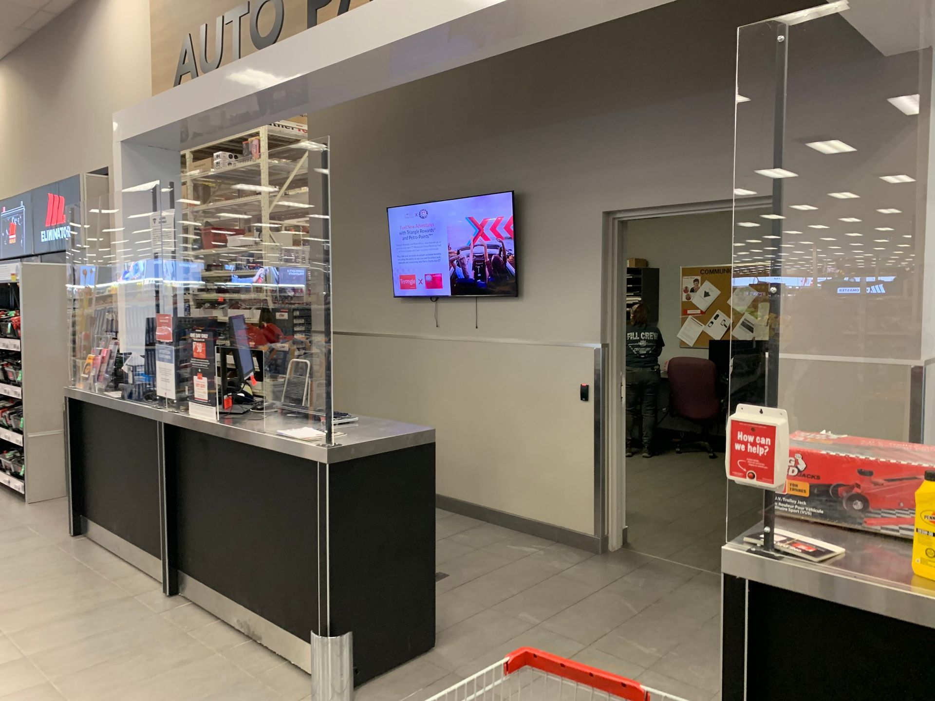 Airport terminal check-in counter with self-service kiosks and a wall-mounted TV digital signage