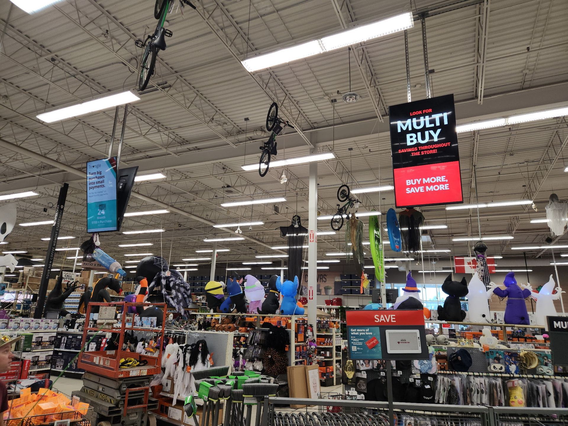 Crowded store interior with hanging signs, shoppers, and rows of merchandise under bright fluorescent lights