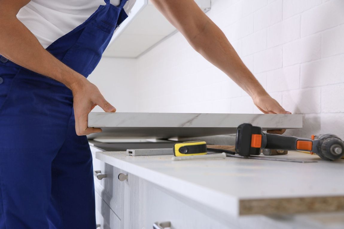 A man is installing a counter top in a kitchen.