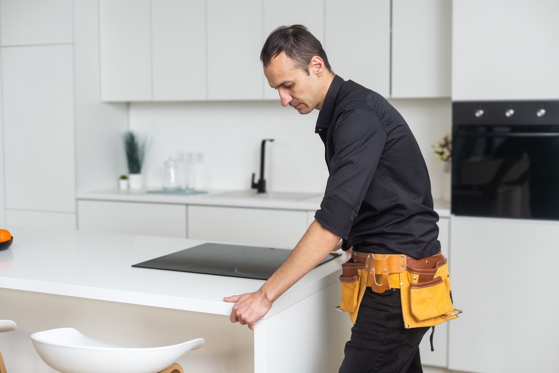 A man is working on a counter in a kitchen.