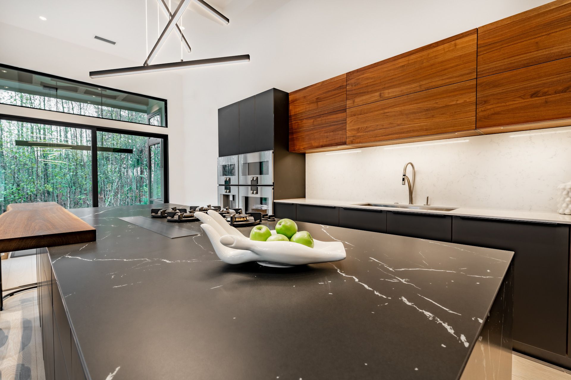 There is a bowl of apples on the counter in the kitchen.
