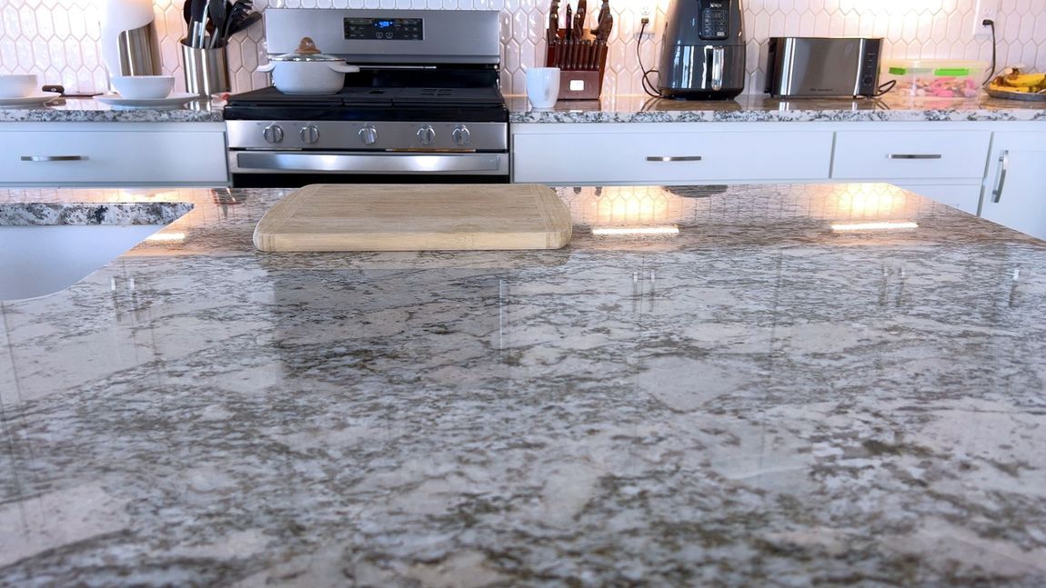 A kitchen with a granite counter top and a stove.