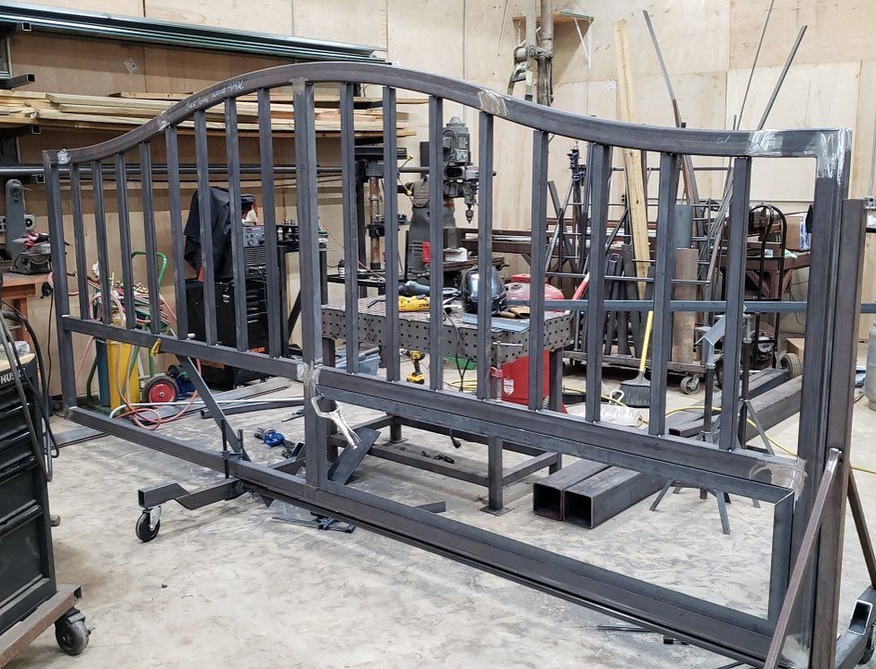 A large metal gate is being built in a factory.