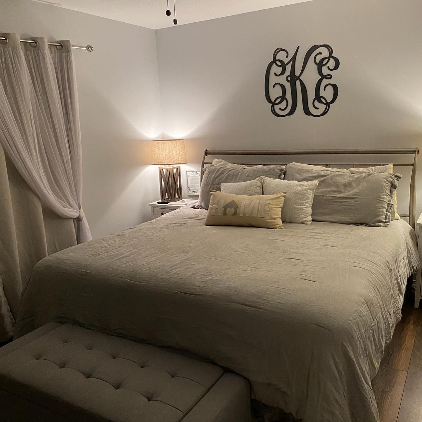 There is a monogram on the wall above the bed.