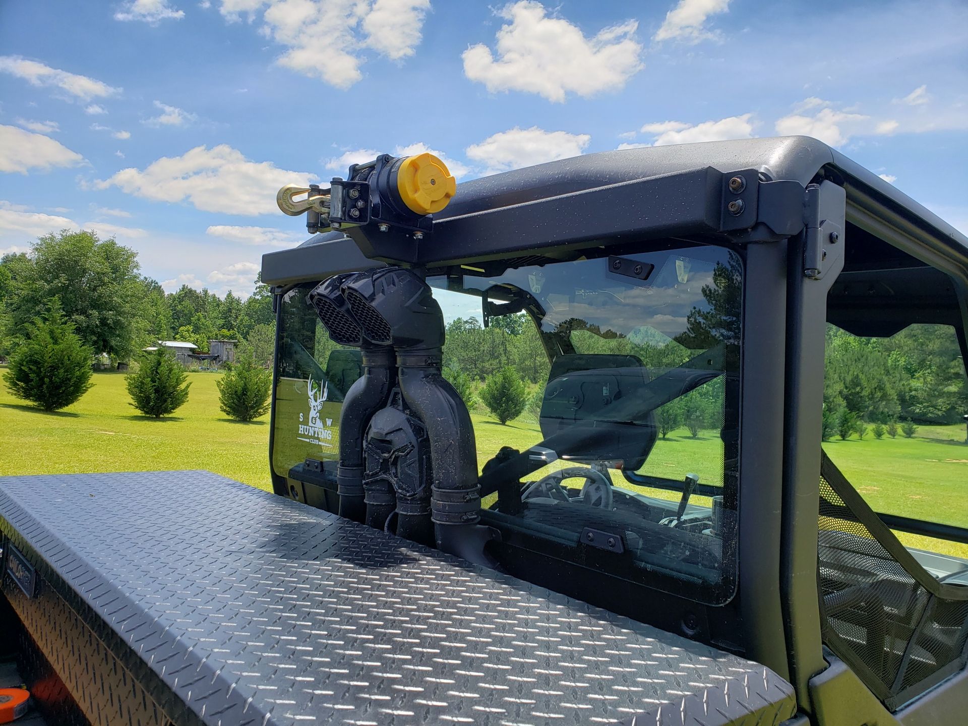 A tractor is parked in a grassy field with trees in the background.