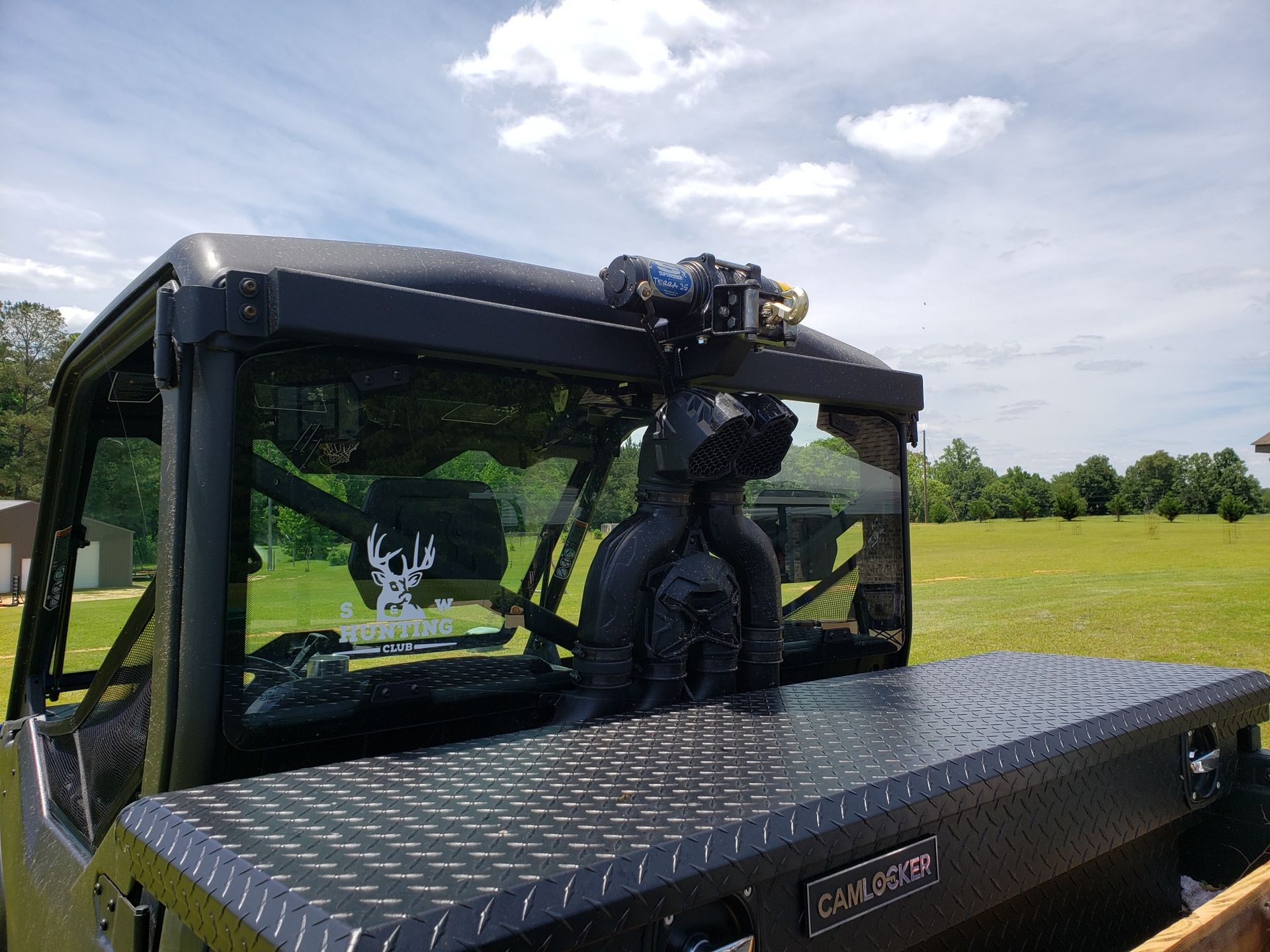 A black truck is parked in a grassy field.