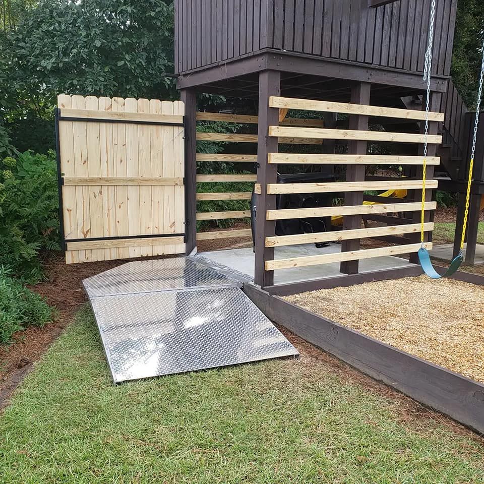 A metal ramp is sitting in front of a wooden structure