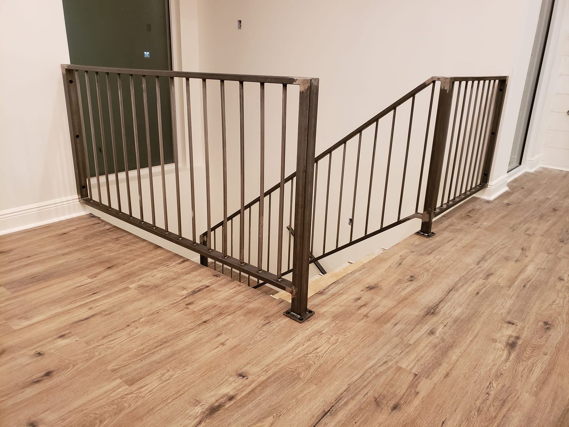 A staircase with a metal railing and wooden floors.