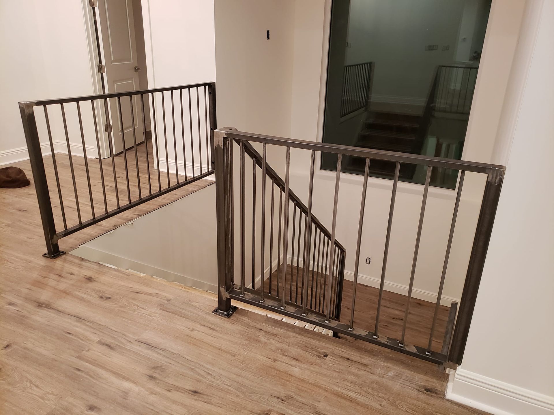 A staircase with a metal railing and a wooden floor.