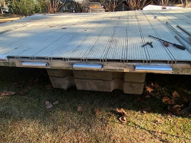 A wooden deck is sitting on top of a lush green field.