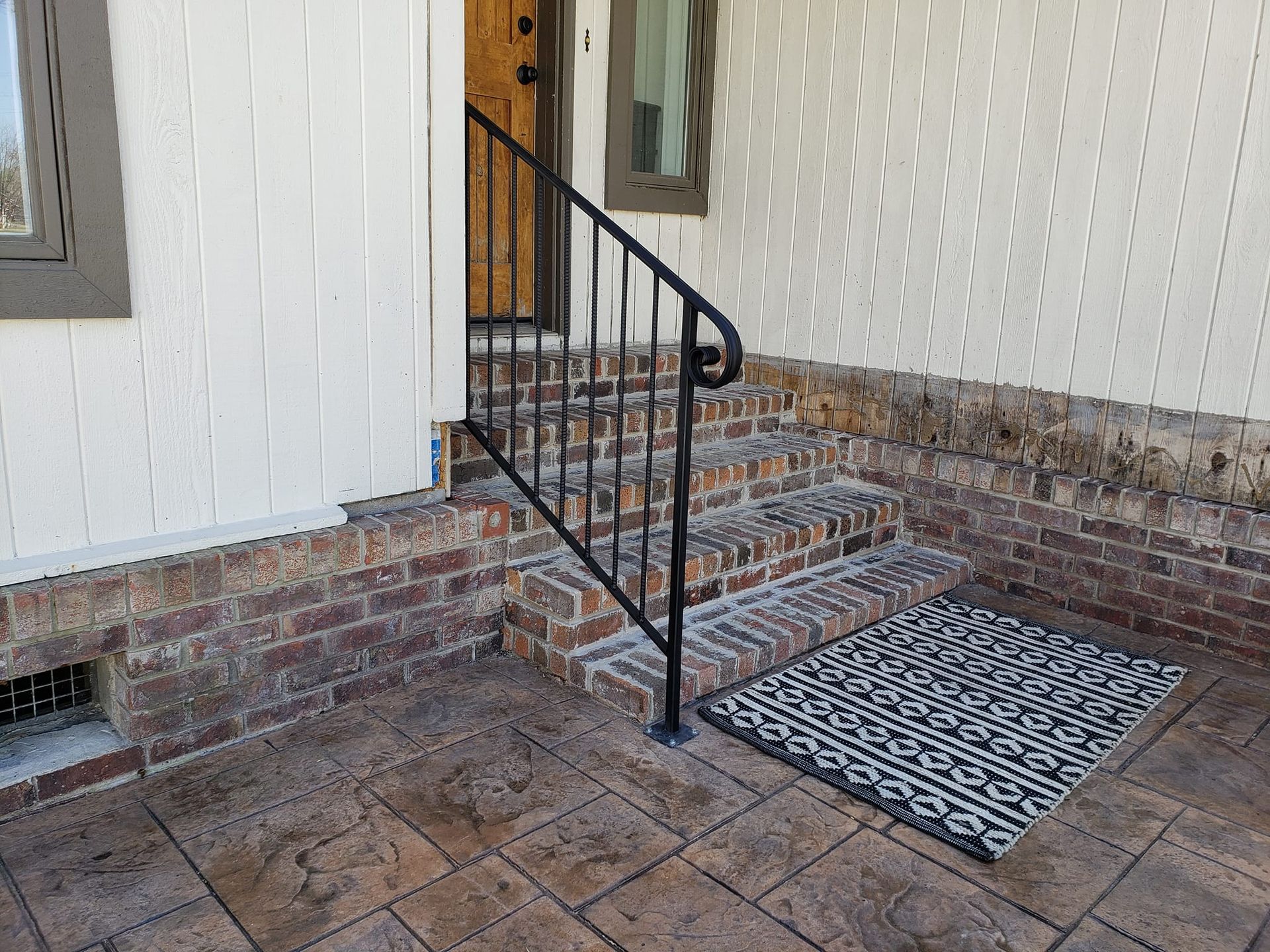 There is a rug on the ground in front of the stairs.