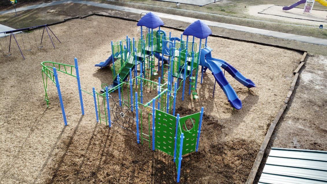 An aerial view of a playground with blue and green equipment.