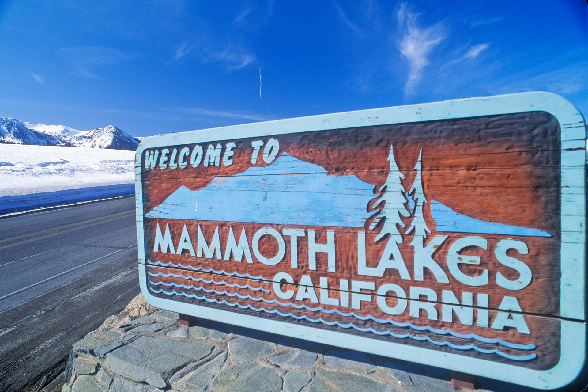Welcome to Mammoth Lakes, California roadside sign with snowy mountains in the background