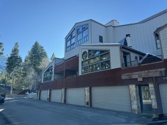 Multi-story building with garages and windows along a quiet street in bright daylight