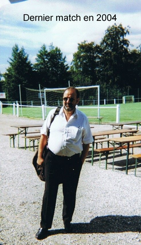 Un homme se tient devant un terrain de football en 2004