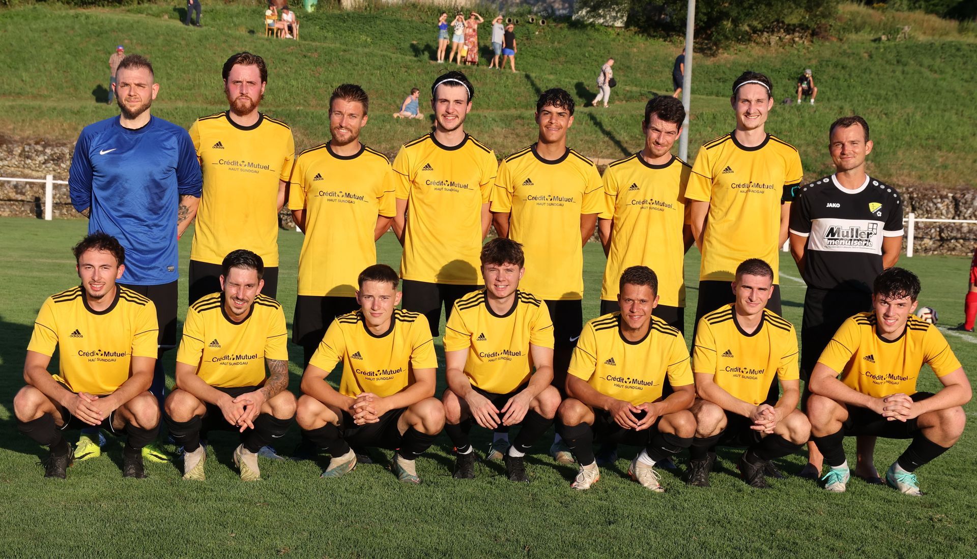 Une équipe de football pose pour une photo sur un terrain.