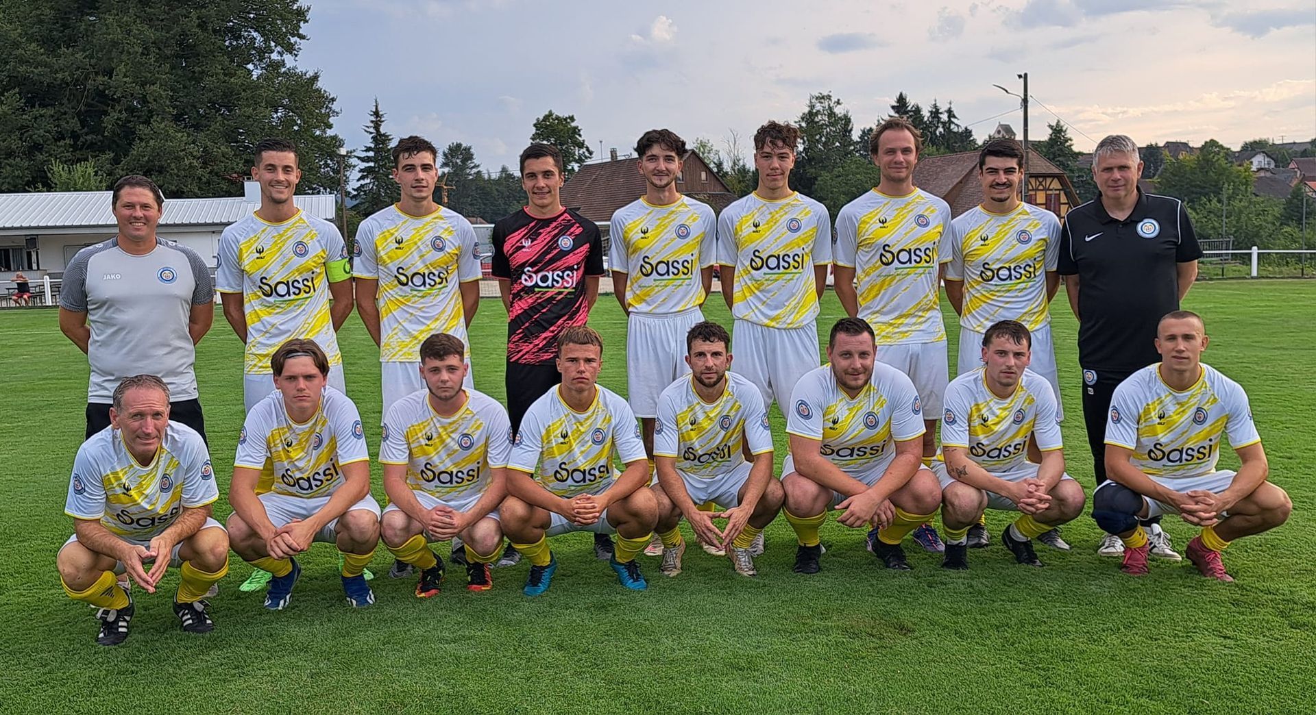 Une équipe de football pose pour une photo sur un terrain.