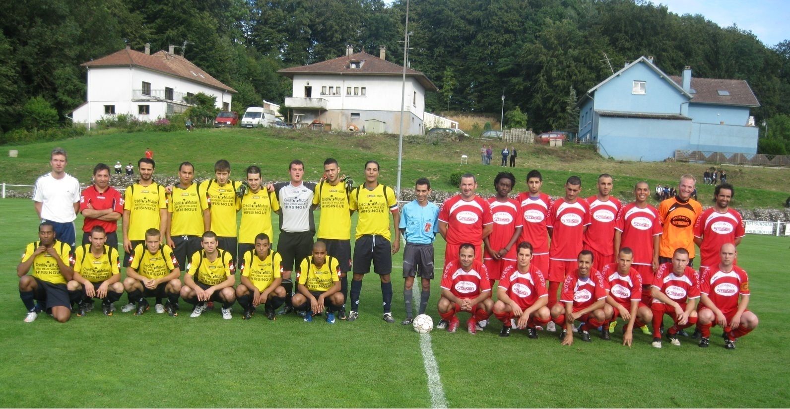 Un groupe de joueurs de football posent pour une photo sur un terrain
